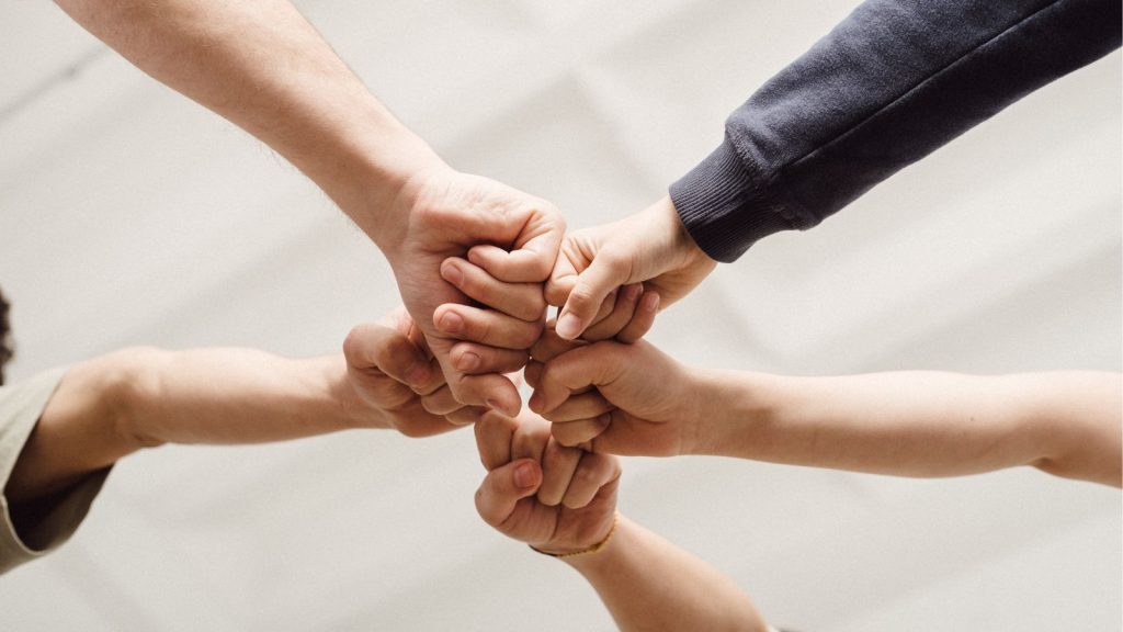 みんなでグーを突き出す写真(ちからを合わせる)